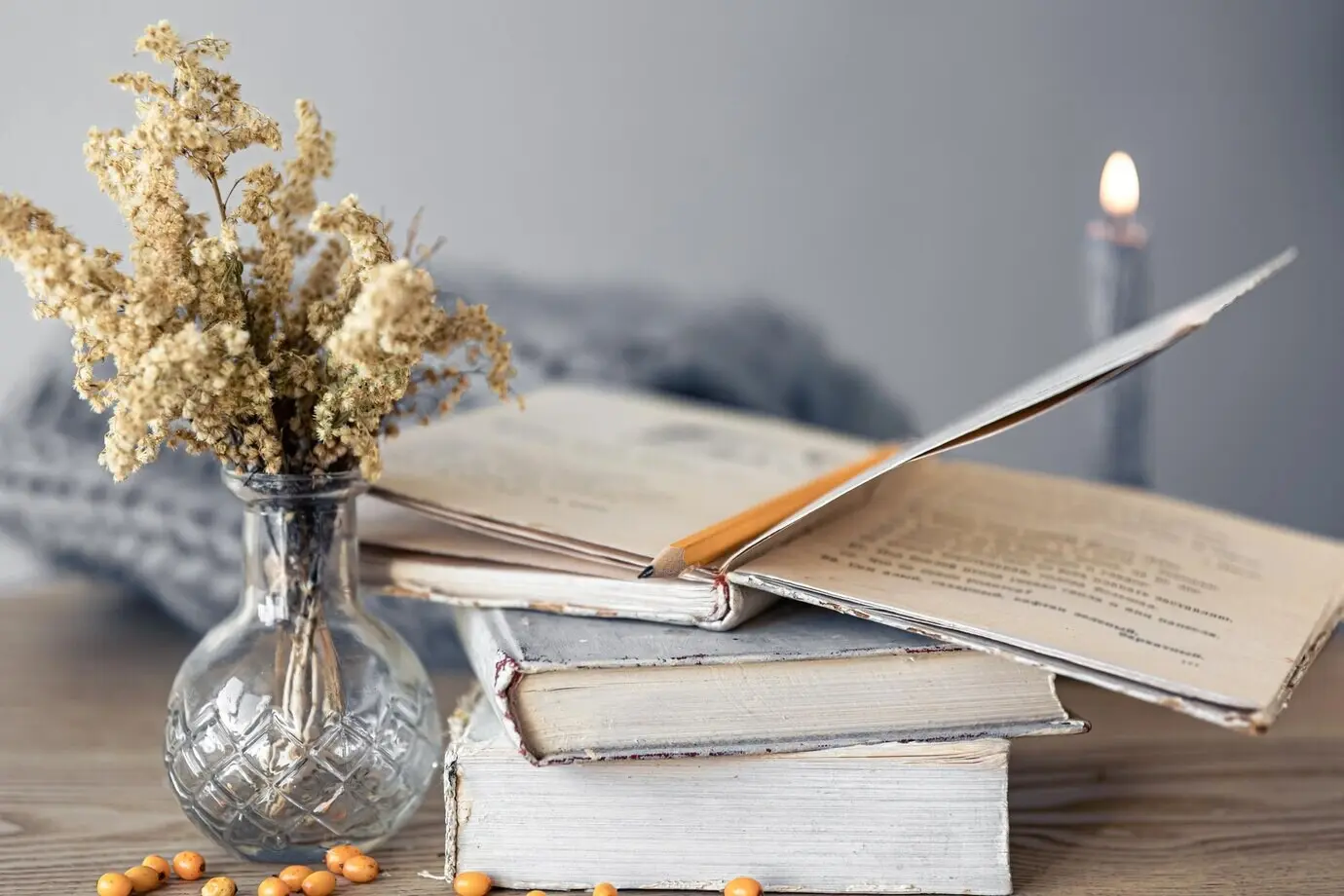 Крупный план уютной домашней композиции с книгами на столе.